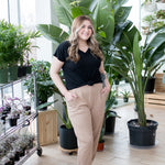 blonde woman standing in black vneck t shirt and jeans