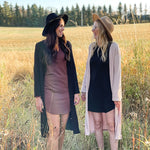 woman wearing black hat, black long cardigan and brown dress 