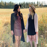 woman wearing black hat, black long cardigan and brown dress 