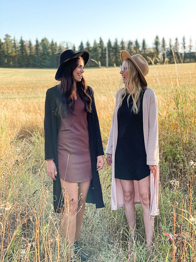 woman wearing black hat, black long cardigan and brown dress 