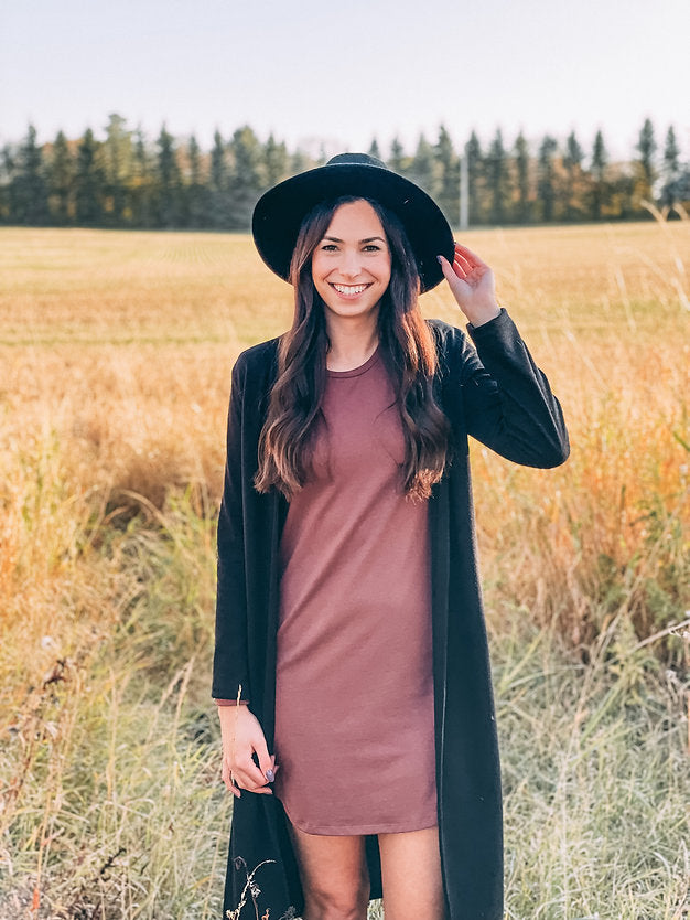 woman wearing black hat, black long cardigan and brown dress 