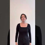 video of woman wearing black square neck top explaining the features
