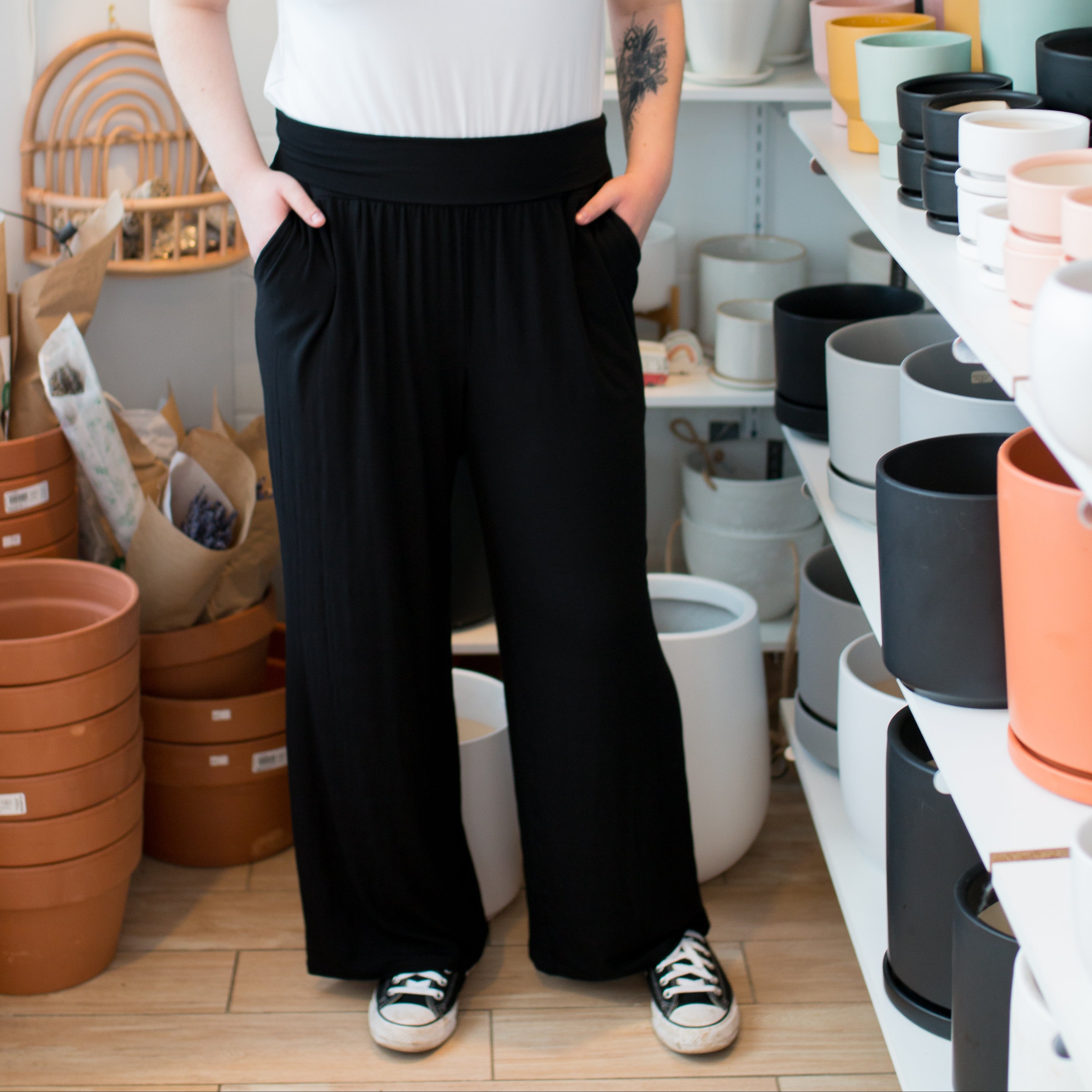 woman wearing a white vneck tshirt and black wide leg pants